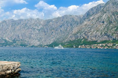 Beyaz yat Kotor Körfezi 'ndeki mavi deniz suyunda.