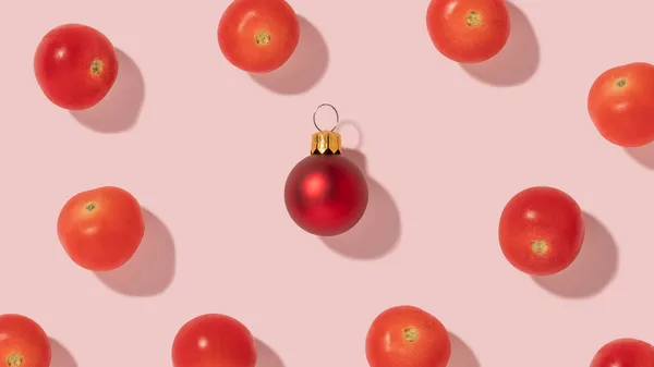 Kreatywny Wzór Kompozycji Świeżymi Pomidorami Wiśniowymi Czerwoną Bombką Świąteczną Jasnoróżowym — Zdjęcie stockowe