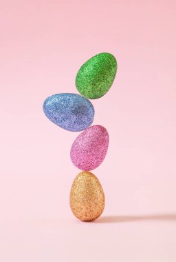 Pastel pembe arka planda renkli paskalya yumurtaları. Mutlu Paskalya trendi konsepti.