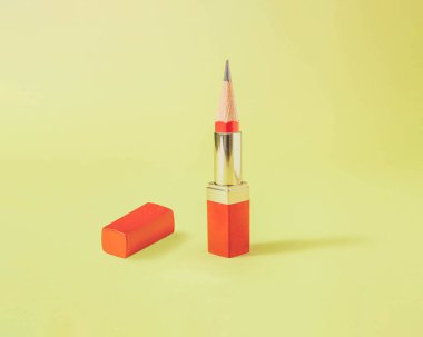 Kırmızı ruj sürgülü sürreal kompozisyon ve altın sarısı arka planda ahşap pancil.