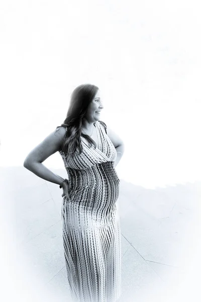 七个月的孕妇穿着五颜六色的条纹连衣裙站在户外 白天的场景 — 图库照片