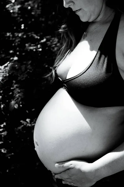 七个月的孕妇穿着牛仔裤在公园里 — 图库照片