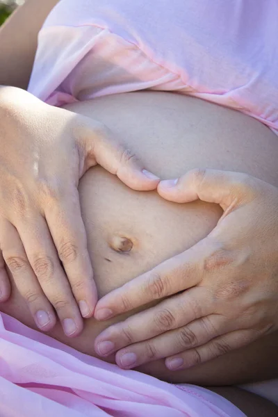 7个月大的怀孕妇女用手做心脏 和平领域 — 图库照片