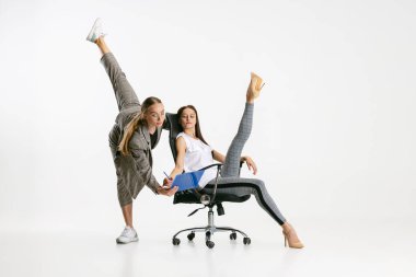 İki kadın, ofisteki günlük giysiler içinde çalışanlar beyaz arka planda izole edilmiş. Balerinler.