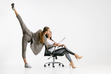 İki kadın, ofisteki günlük giysiler içinde çalışanlar beyaz arka planda izole edilmiş. Balerinler.