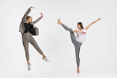 İki kadın, beyaz arka planda yalnız dans eden gündelik giysiler içinde çalışanlar. Balerinler