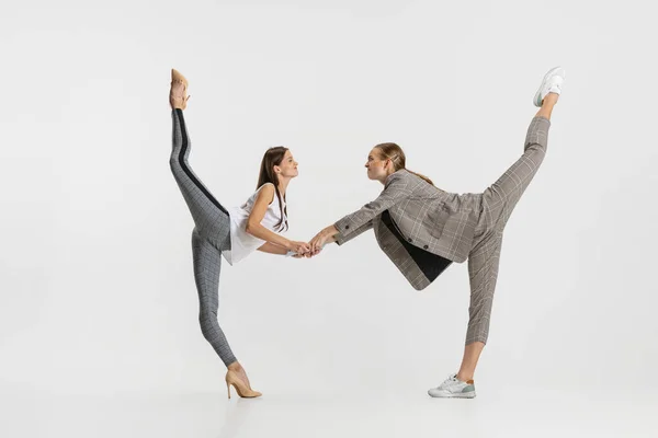 Dos mujeres en la oficina haciendo ballet estirándose aisladas sobre fondo blanco. Haciendo caras —  Fotos de Stock