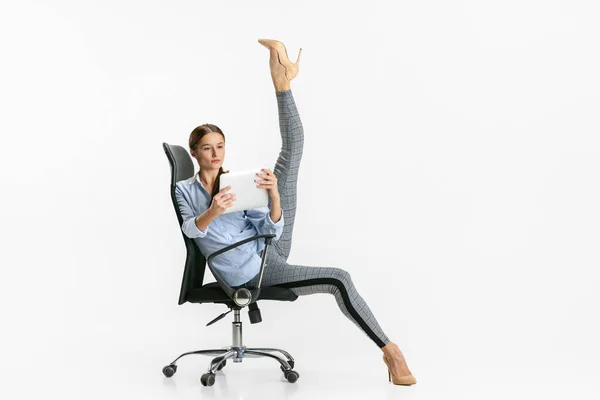 Retrato de mujer, oficinista de pie en silla en pose de ballet y lectura de tableta aislada sobre fondo blanco —  Fotos de Stock