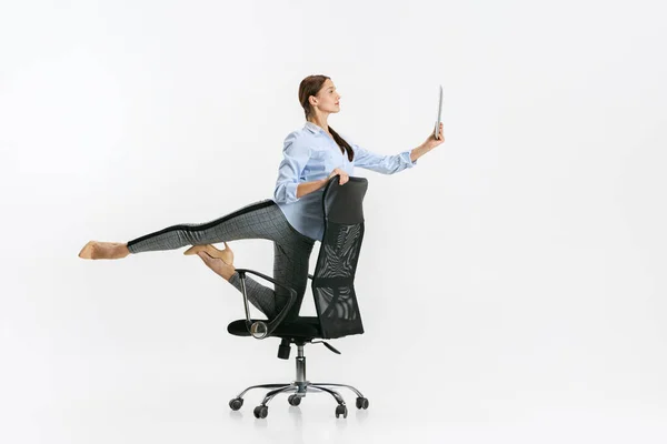 Retrato completo de mujer, oficinista de pie en silla en pose de ballet y lectura de tableta aislada sobre fondo blanco —  Fotos de Stock