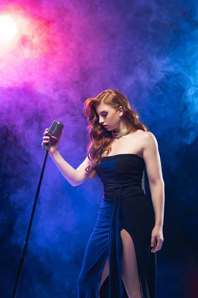 年轻艺术家的肖像画，女爵士歌手在霓虹灯下被隔离在深蓝色的背景之上。爵士音乐 — 图库照片