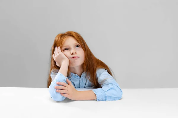 Обрізаний портрет маленької дівчинки, зіниця відчуває нудний, підстрибуючи щоки ізольовані на сірому фоні — стокове фото