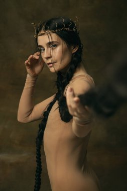 Klasik arka planda izole edilmiş uzun siyah örgülü taç giymiş güzel bir kadının yan görünüm sanat portresi. Bale gösterisi