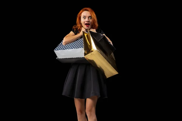 Ritratto di donna felice ed eccitata che tiene molte borse dopo aver fatto shopping con successo isolato su sfondo nero. Vendite — Foto Stock