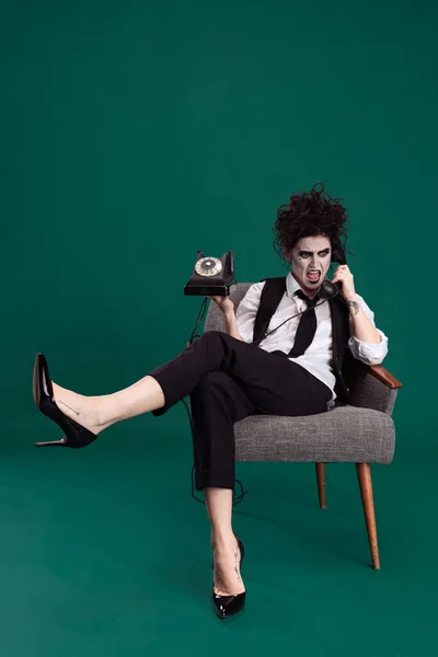 Full längd porträtt av konstnärlig kvinna i Halloween kostym skrika på vintage telefon isolerad över grön bakgrund. Halloween-konceptet — Stockfoto