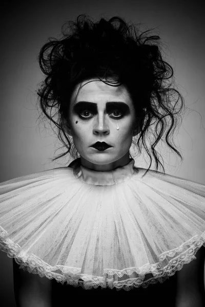 Retrato de mujer llorona de aspecto espeluznante en traje vintage y maquillaje espeluznante aislado sobre fondo oscuro. Imagen en blanco y negro. Halloween —  Fotos de Stock