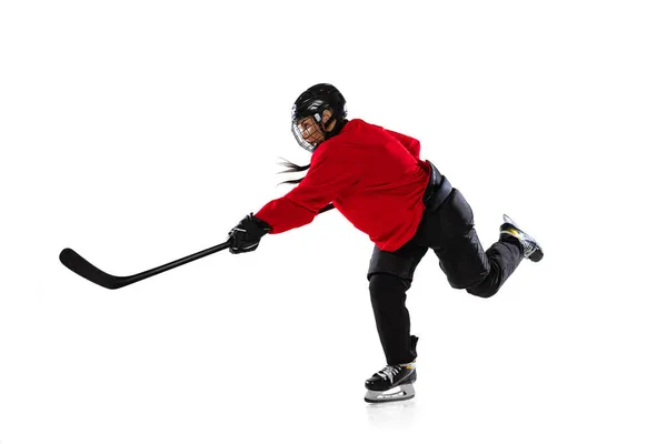 Full-length portrait of professional female hockey player training in special uniform with helmet isolated over white background. In motion. Goal — Stock Photo, Image
