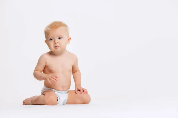 Retrato de cuerpo entero de una niñita linda, bebé sentado tranquilamente en pañal aislado sobre fondo blanco del estudio — Foto de Stock