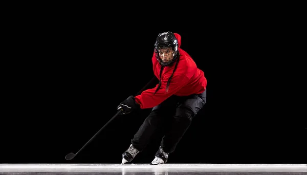 Full-length portrait of professional female hockey player training isolated over black background. Stickhandling — Stock Photo, Image