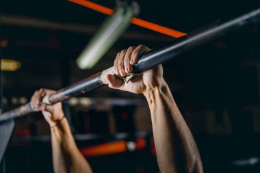 Güçlü erkek ellerinin barfiks egzersizi yaparken yakın plan görüntüsü. Spor salonunda erkek eğitimi.