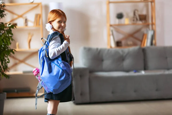 Портрет маленькой улыбающейся девочки, ученицы в синей школьной форме и большой рюкзак. Быть готовым к школе — стоковое фото