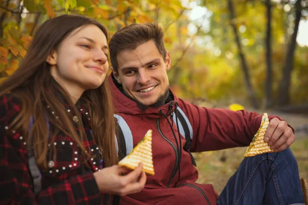 Обрізаний портрет молодої красивої пари, яка має пікнік в теплий осінній день у лісі. Пішохідна активність — стокове фото