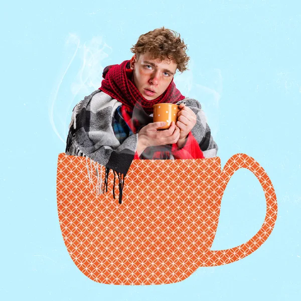 Collage d'art contemporain de garçon malade dans une écharpe avec une tasse de thé assis dans une tasse à gros motif isolé sur fond bleu — Photo