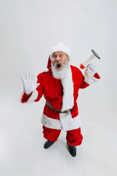 Retrato de cuerpo entero del jubiloso hombre mayor con traje de Papá Noel con megáfono aislado sobre fondo blanco. Felices fiestas —  Fotos de Stock