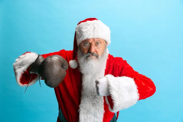 Retrato recortado del hombre mayor con traje de Papá Noel y guante de caja aislado sobre fondo azul —  Fotos de Stock