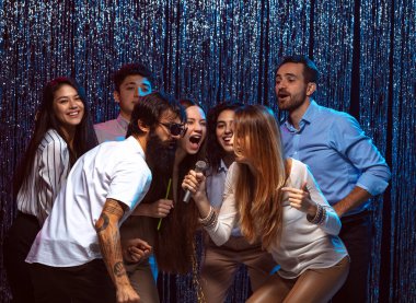 Karaokenin tadını çıkarıyorum. Bir grup genç kutlamada eğleniyor.