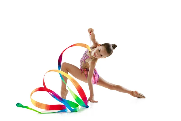 Полнометражный портрет маленькой девочки, профессиональная художественная гимнастика, выступление с красочной лентой на белом фоне — стоковое фото