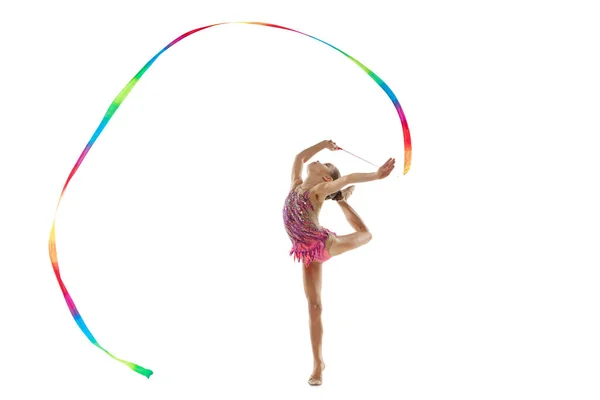 Full-length portret van klein meisje, professionele ritmische gymnastiek training, uitvoeren met kleurrijke lint geïsoleerd over witte achtergrond — Stockfoto