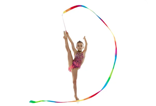 Ganzkörperporträt eines kleinen Mädchens, einer professionellen rhythmischen Turnerin, die in Bindstellung steht, mit Band isoliert über weißem Hintergrund — Stockfoto