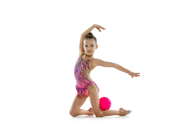 Full-length πορτρέτο του μικρού κοριτσιού, ρυθμική γυμναστική εκπαίδευση, άσκηση με μπάλα απομονώνονται σε λευκό φόντο — Φωτογραφία Αρχείου