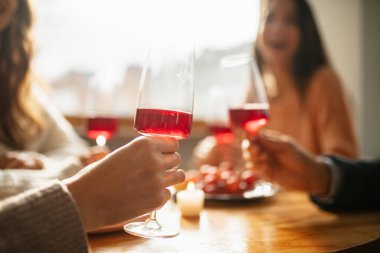 Şarap kadehlerinin yakın plan görüntüsü, tıkırtı. Sıcak ve güneşli bir günde kafede buluşuyoruz.