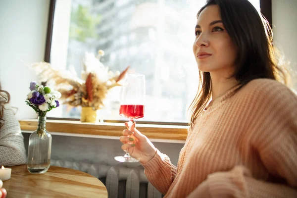 Portret pięknej kobiety z czerwonym szklanym winem siedzącej w kawiarni w jasny dzień — Zdjęcie stockowe
