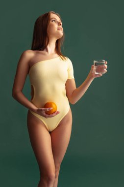 Sarı elbiseli güzel bir kadının yeşil arka planda izole edilmiş portresi.