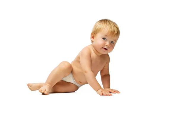 Retrato de pequeño niño lindo, bebé en pañal posando aislado sobre fondo blanco del estudio. Vista lateral — Foto de Stock