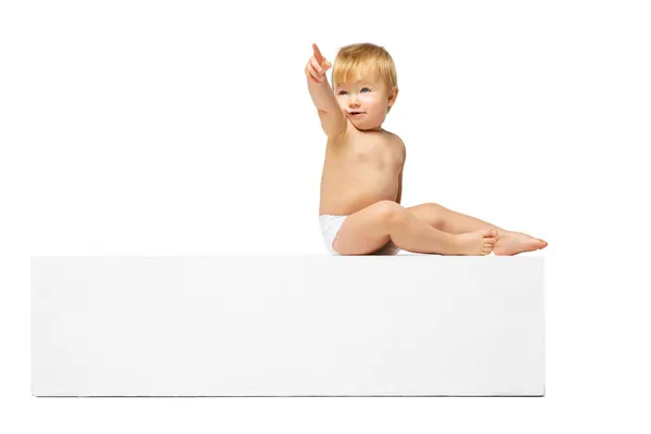 Retrato de pequeno menino bonito, bebê de fralda sentado isolado sobre fundo de estúdio branco. Vista lateral — Fotografia de Stock