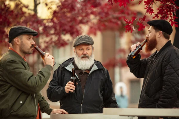 Gruppo di amici maschi trascorrere del tempo insieme all'aperto nella calda giornata autunnale. Bere birra lager — Foto Stock