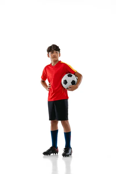 Retrato de cuerpo entero del joven, adolescente, futbolista profesional en uniforme con la pelota posando aislado sobre fondo blanco —  Fotos de Stock