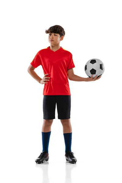 Retrato completo de menino, adolescente, jogador de futebol profissional em uniforme com bola posando isolado sobre fundo branco — Fotografia de Stock