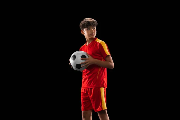 Przycięty portret młodego chłopca, nastolatka, profesjonalny piłkarz w mundurze z piłką pozowanie izolowane na białym tle — Zdjęcie stockowe