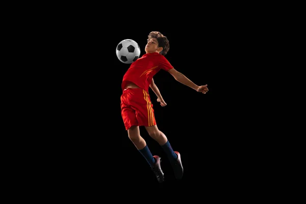 Full-délka portrét chlapce, teenager, profesionální fotbalista v pohybu izolované přes černé pozadí — Stock fotografie