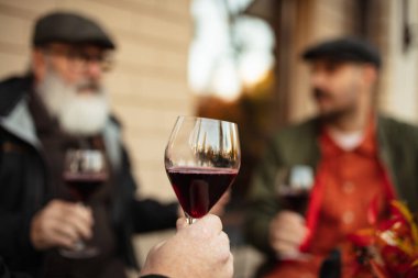 Lezzetli kırmızı şarapla dolu camın yakın plan görüntüsü. Arkadaşlar kafede toplanıyor.