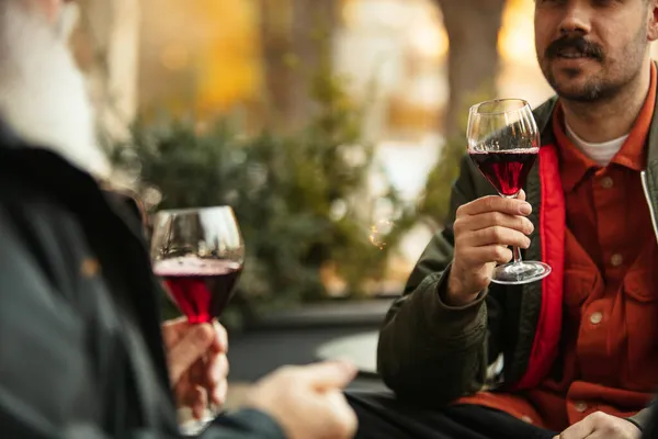 Bicchieri di delizioso vino rosso. Amici che si riuniscono al caffè nella calda giornata autunnale — Foto Stock