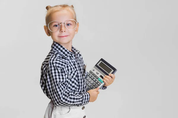 Cropped portrait of cute little girl with calculator isolated over gray background — Stock Photo, Image