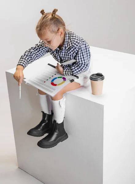 Cropped portrait of cute little girl with diagram pointing down isolated over gray background — Stock Photo, Image