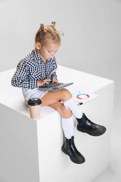 Cropped portrait of cute little girl making notes, countng isolated over gray background. Accountant — Stock Photo, Image