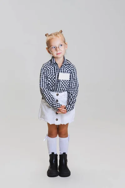 Pełna długość portret małej uroczej dziewczynki, dziecko w okularach i koszuli w kratkę izolowane na szarym tle — Zdjęcie stockowe