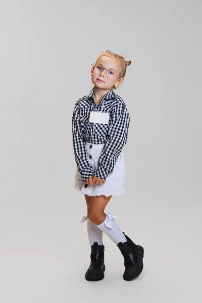 Retrato de comprimento completo de menina bonito pouco, criança em óculos e camisa xadrez isolado sobre fundo cinza — Fotografia de Stock